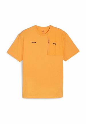 Orange kortærmet t-shirt lavet af bomuld, med en lynlåslomme og et sort Puma-logo på brystet. Enkelt rundt halsdesign.