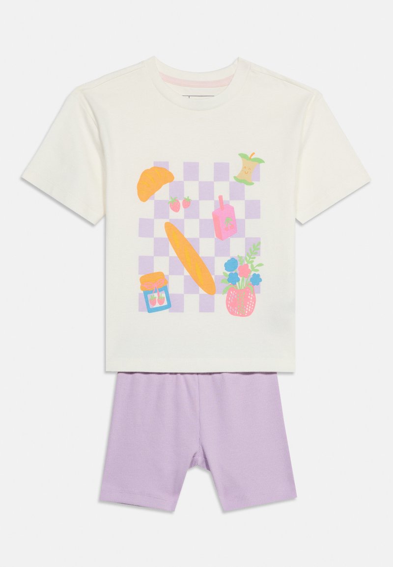 Κρεμ πουκάμισο με κοντά μανίκια και παστέλ μοβ καρό σχέδιο, με εικονογραφήσεις κρουασάν, φράουλες, μπαγκέτα, βάζο, χυμό, κεντρικό μέρος μήλου και λουλούδια, σε συνδυασμό με ανοιχτό μοβ σορτς.