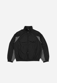 Black windbreaker jacket with gray accents, featuring a zip front, elastic waist, and textured panel with a grid pattern on the front.