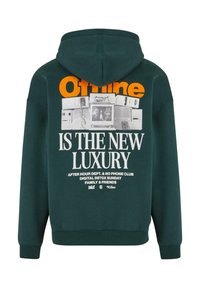 Sudadera con capucha de color verde oscuro que presenta un estampado gráfico en naranja y blanco. Incluye texto e imágenes de ordenadores retro en la parte posterior.