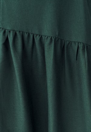 Tessuto verde scuro con una texture liscia, caratterizzato da un design arricciato in vita, che crea una silhouette fluida.