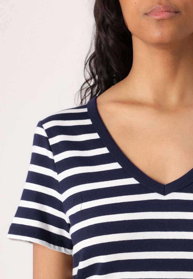 Granatowa i biała koszulka w paski z dekoltem w serek, wykonana z miękkiego materiału, z krótkimi rękawami i dopasowanym fasonem.