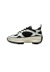 Schwarzer und weißer Sneaker aus Netz- und glattem Leder, mit einer dicken Sohle, die mit spitzen Noppen versehen ist, und einem Zugriemen an der Ferse.