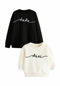 Czarna bluza z napisem "MaMa" białą czcionką oraz kremowa bluza z napisem "Mini" czarną czcionką, obie z zaokrąglonym dekoltem i ściągaczami na rękawach.