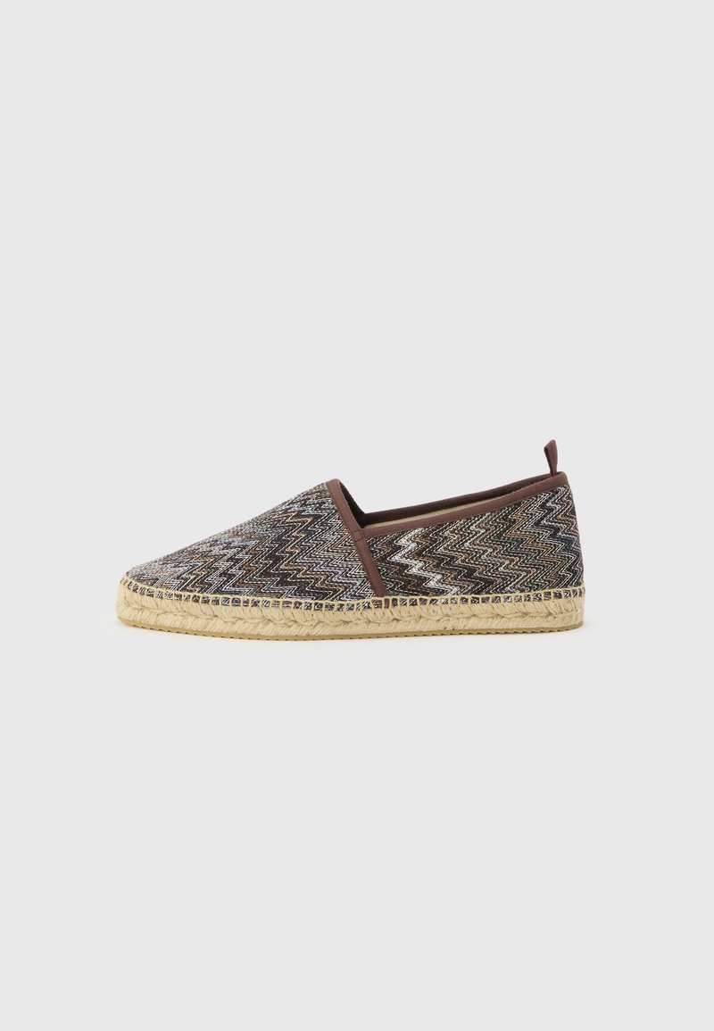 Espadrille à enfiler avec tige en tissu marron à motif zigzag, bordure marron et semelle en jute tressé sur fond gris clair.