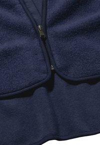 Dunkelblaues Fleece-Oberteil mit Reißverschluss, das eine glatte Textur, elastische Kanten und ein geschichtetes Design am Kragen und Saum aufweist.