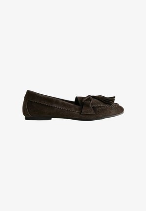Mocassin en daim brun foncé avec un nœud et un détail à pompon sur le devant et une semelle noire plate.