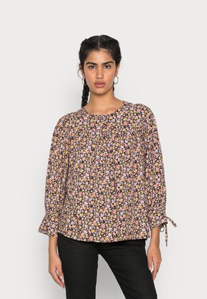 Blusa floral com um fundo preto adornado com pequenas flores em rosa, amarelo e branco, mangas longas com detalhes em laço e um decote redondo.