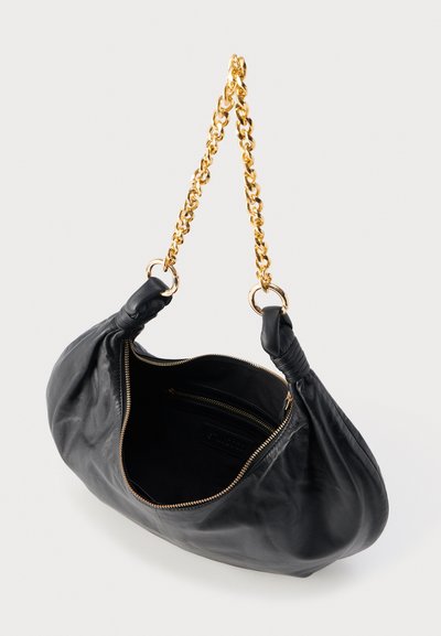 Sac à main en cuir noir avec bandoulière chaîne dorée, fermeture éclair sur le dessus et poche intérieure zippée, présenté ouvert sur fond blanc.