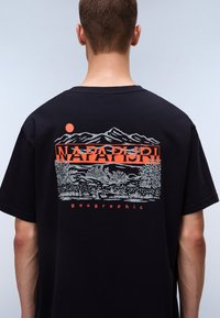 Black cotton t-shirt featuring a graphic design of mountains and trees with orange and gray accents, including the text "NAPAPIJRI" and "geographic."