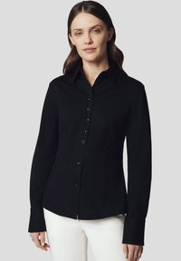 Czarna koszula z guzikami, z długimi rękawami, dopasowany krój i klasyczny kołnierzyk. Posiada gładką fakturę oraz subtelne detale guzików.