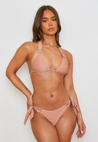 Roze gouden bikini set met een gestructureerde, glinsterende afwerking. Bevat een triangletop met brede bandjes en decoratieve hardware op de bikini-onderdelen.
