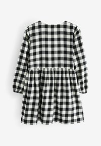 Rob e à carreaux noir et blanc avec des manches longues, taille froncée et encolure arrondie, fabriqué en tissu doux.