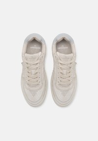 Beige Wildlederschuhe mit hellgrauen Akzenten, runder Zehenpartie, flachen Schnürsenkeln, perforierten Details und geprägtem Logo auf der Zunge.