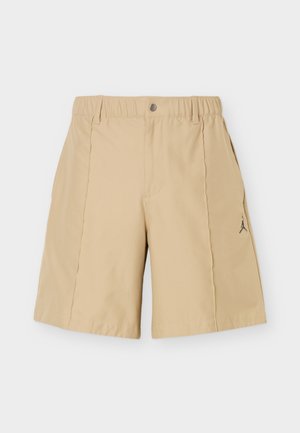 Beige knee-length shorts with elastic waistband, button closure, belt loops, side pockets, and small black logo on the right leg.