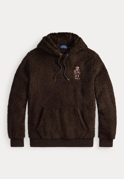 Sudadera con capucha de sherpa marrón con una textura esponjosa, capucha ajustable con cordón, bolsillo frontal y logo de un oso bordado cerca del pecho.