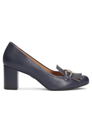 Pantofole in pelle blu navy con punta arrotondata, tacco a blocco, decorazione a fiocco e dettaglio frangiato, e un accento metallico sulla parte anteriore.
