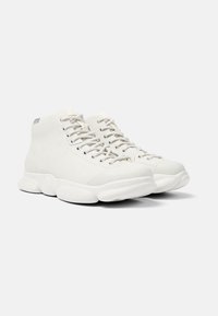 Białe sneakersy sięgające za kostkę, wykonane z gładkiego materiału, z okrągłym noskiem, grubą amortyzującą podeszwą oraz płaskimi sznurowadłami z metalowymi oczkami.