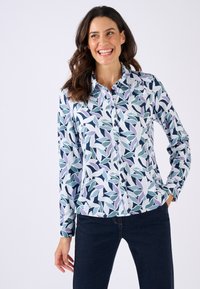 Overhemd met knopen featuring een bloemenpatroon in tinten van blauw, groen en lila op een witte achtergrond. Lange mouwen en een kraag.