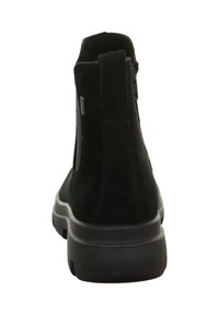 Schwarzer Wildleder-Ankle-Boot mit strukturiertem Material, elastischen Seitenteilen und einer dicken schwarzen Gummisohle, die für Komfort und einfaches Tragen entworfen ist.