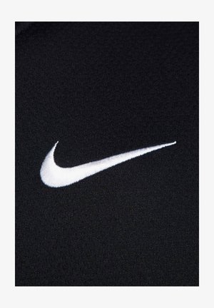 Črn material z fino teksturo, ki ima izstopajoč bel izvezeni Nike swoosh logotip. Preprost, atletski dizajn.