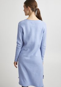 Abito a maglia azzurro chiaro con maniche lunghe, scollatura rotonda e spacchi laterali. Texture morbida e design di lunghezza media.