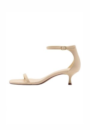 Beige læder sandal med lav hæl, tynd tårem og justerbar ankelrem med lille spænde.