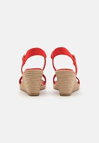 Sandali con zeppa in suede rosso, con tacco in sughero di juta texturizzato e schienale aperto, dotati di cinturini alla caviglia regolabili e design della punta arrotondato.