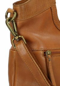Borsa a mano in pelle marrone con superficie testurizzata, minuteria in ottone, tracolla regolabile e tasca con zip sul lato.