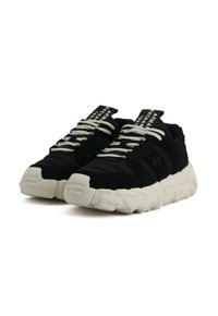 Sneaker bianco e nero con suole bianche spesse, lacci bianchi e testo "ARMANI EXCHANGE 1991" sulle etichette nere della linguetta.