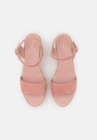 Rosa mockaskinnsplattformssandaler med två breda remmar. Har justerbar spänne vid ankeln, mjuk innersula och vävd hampa-liknande detalj på sulan.