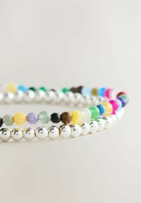 Armband i pärlor med glänsande silverkulor och färgglada, runda stenar i olika nyanser, inklusive blå, gul, grön och rosa.