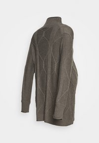 Grå stickad tröja med hög krage, prydd med ett diamantmönster och ribbade muddar. Designen är lös med långa ärmar.