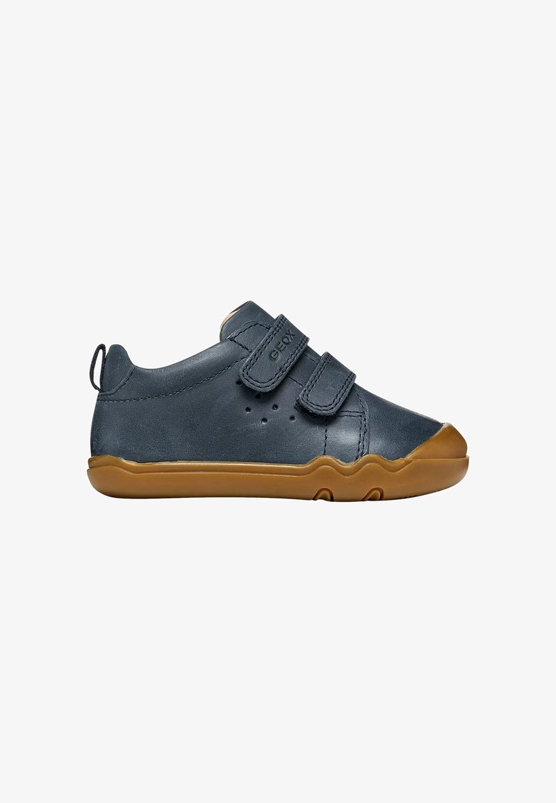 Chaussure bébé bleu marine avec semelle en caoutchouc marron, deux sangles Velcro ajustables et languette au talon.