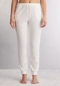 Crème rib joggerbroeken met een verstelbare koord in de taille, zijzakken en aansluitende boorden bij de enkels. Zachte textuur.