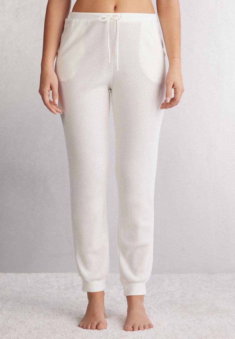 Crème rib joggerbroeken met een verstelbare koord in de taille, zijzakken en aansluitende boorden bij de enkels. Zachte textuur.