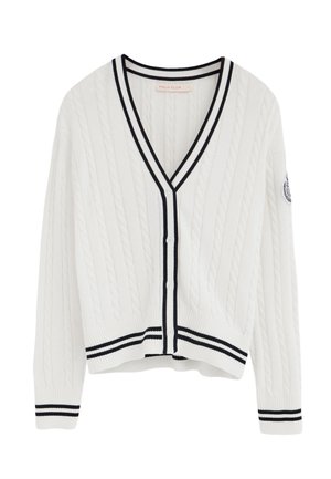 Cardigan blanc en maille torsadée avec bordures noires sur l'encolure en V, la patte de boutonnage, les poignets et l'ourlet, avec un petit patch logo sur la manche gauche.