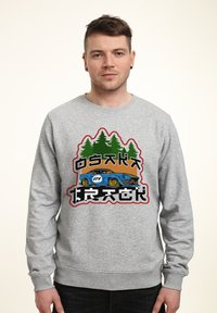 Grauer Sweatshirt mit einem grafischen Design eines blauen Autos und grünen Bäumen, kräftigem Text, runder Ausschnitt und gerippten Bündchen.