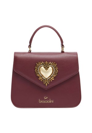 Borsa in pelle color bordeaux con ornamento a forma di cuore in oro decorato con gioielli. Presenta un design strutturato e un manico superiore.