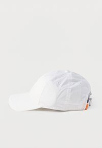 Λευκό καπέλο baseball με καμπύλη γείσο, οπές αερισμού και ρυθμιζόμενο μεταλλικό λουράκι στο πίσω μέρος, σε απλό φωτεινό φόντο.