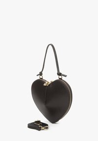 Sac à main en forme de cœur noir en cuir texturé, doté d'une anse supérieure, de ferrures dorées et d'une bandoulière amovible.