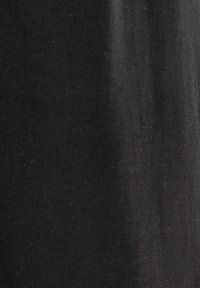 Černá látka s mírně texturovaným povrchem, zobrazující jemné variace v odstínech a lesku. Materiál se zdá být hladký a lehký.