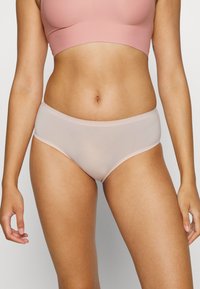 Ljust rosa hipsterunderkläder i slätt material, med en mjuk elastisk midjeband och sömlös design för komfort och ett rent avslut.