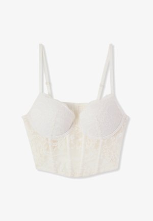 Reggiseno lungo in pizzo bianco con coppe con ferretto e spalline regolabili, caratterizzato da motivi floreali e cuciture strutturate.