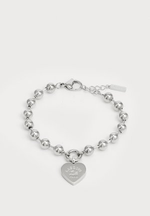 Bracelet en argent avec des perles rondes et un charm en forme de cœur gravé "Lacoste Paris." Comprend un fermoir à ressort pour la fermeture.