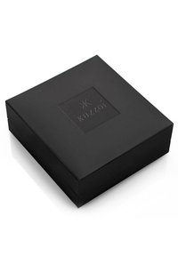 Scatola regalo rettangolare nera con superficie testurizzata e un logo quadrato in rilievo sulla parte superiore. Nessun hardware o accenti visibili.