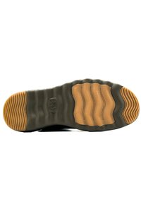 Suela de sneaker negra con una banda de goma color caramelo. Presenta patrones en forma de ola y textura ribeteada para mayor agarre. Logo visible en un lateral.