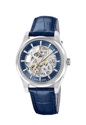 Silberne Festina Armbanduhr mit blauem Lederarmband, skelettiertem Zifferblatt mit sichtbaren Zahnrädern, silbernen Stundenmarkierungen und Swiss made Schriftzug.