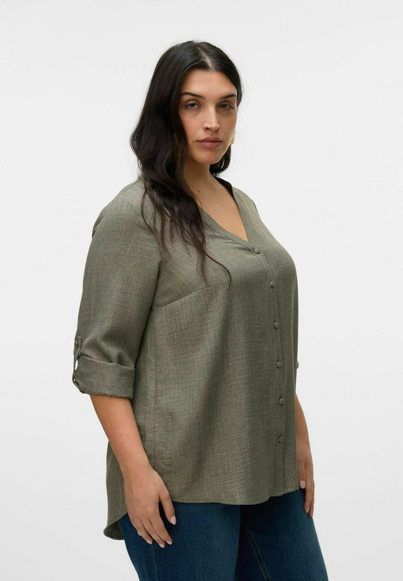 Chemise olive verte à col en V, manches trois-quarts retroussées avec un onglet, en tissu texturé et à coupe ample.