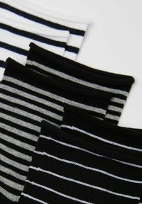 Pruhované ponožky v černé, bílé a šedé barvě. Měkký bavlněný materiál s různými šířkami pruhů, s kontrastními žebrovanými lemy.